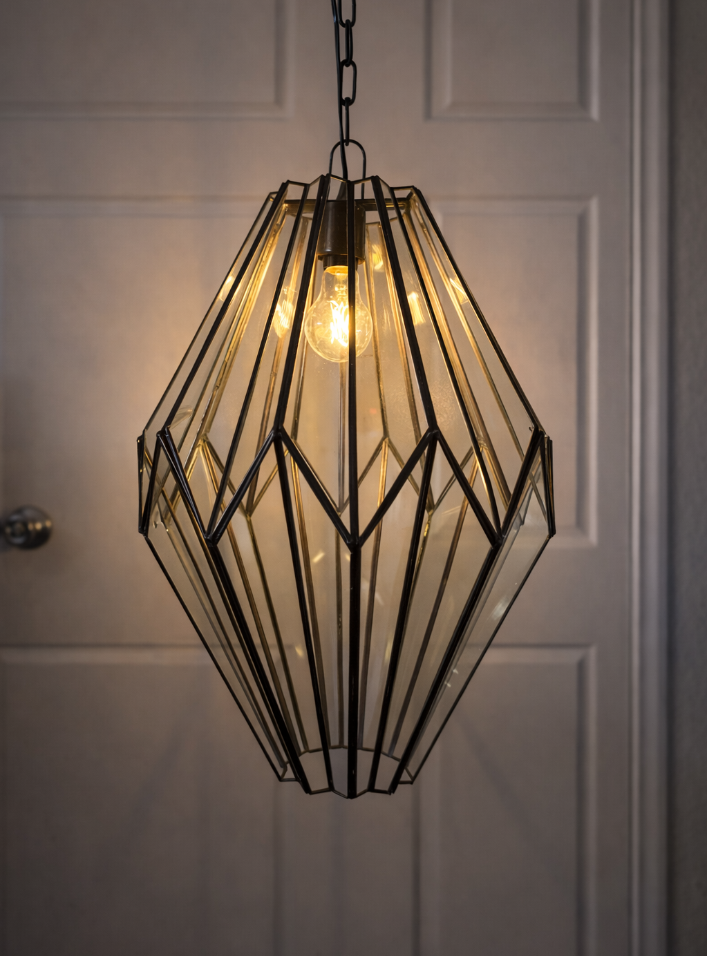 Decorative pendant light with geometric design against a neutral background